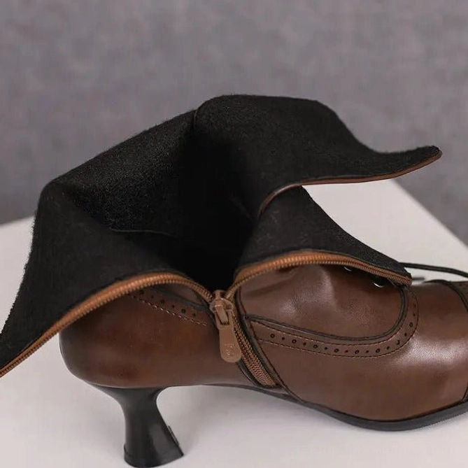 Steampunk boot side detail showing black lining and brogue perforations - close-up of side zipper closure mechanism