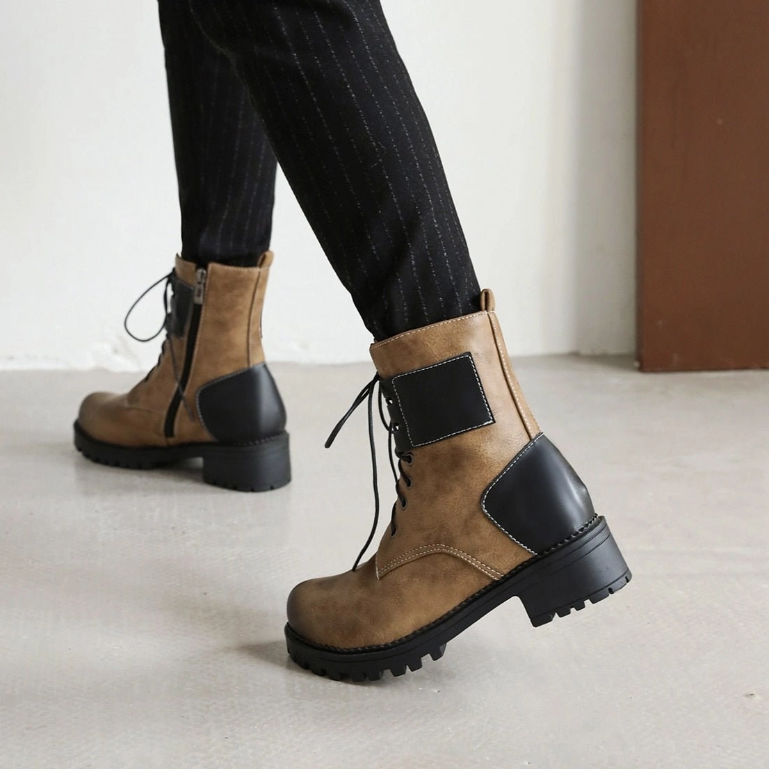 Steampunk boots back view on model - visible side zipper closure, black heel accents, industrial construction details, and faux leather upper