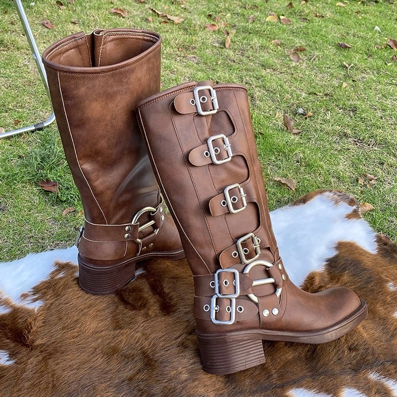 Brown steampunk boots with stacked buckle straps and thick block heel, side profile outdoor display