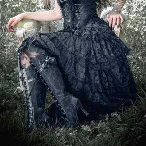 Gothic steampunk outfit styling featuring black lace knee-high boots with bow accents worn with dark gown and sheer stockings in woodland setting