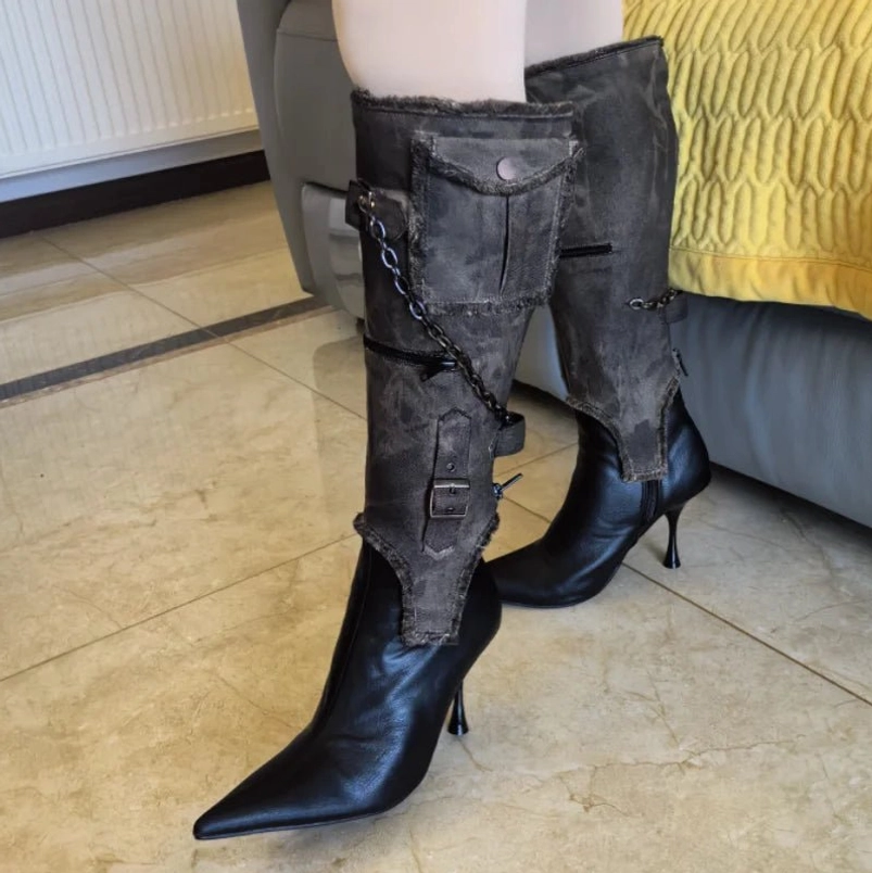 Steampunk style mid-calf boots worn on model legs, distressed leather with frayed canvas cuffs and metal chains, indoor home setting