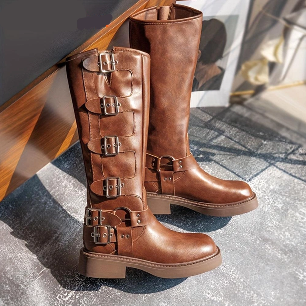 Brown steampunk knee-high boots with block heel and multiple silver buckles, side profile view in indoor setting