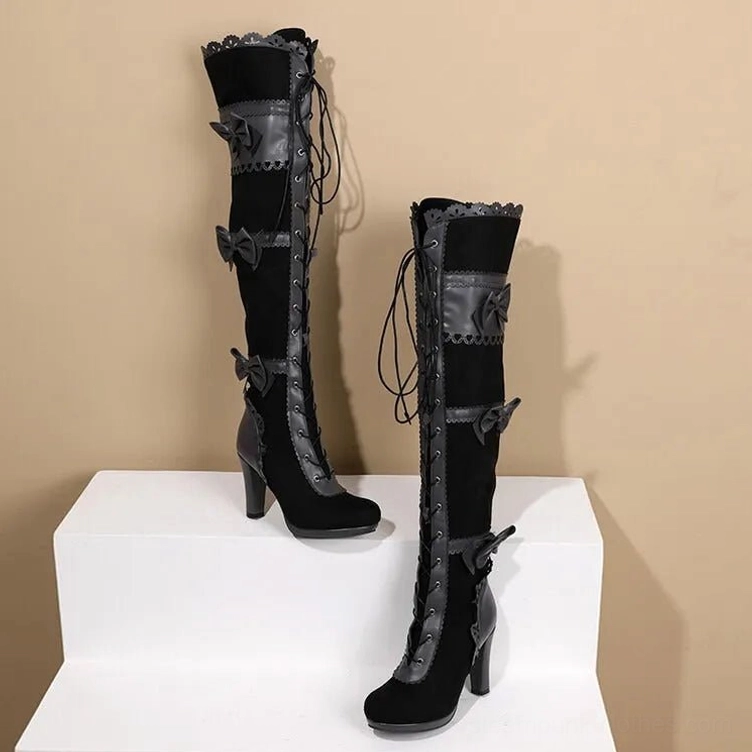 Victorian steampunk over-the-knee boots three-quarter side view showing block heel, multiple bow embellishments, and leather panel details
