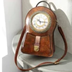 Steampunk clock crossbody bag in distressed brown genuine leather featuring functional Roman numeral clock face, brass hardware, and front three-quarter display view on table