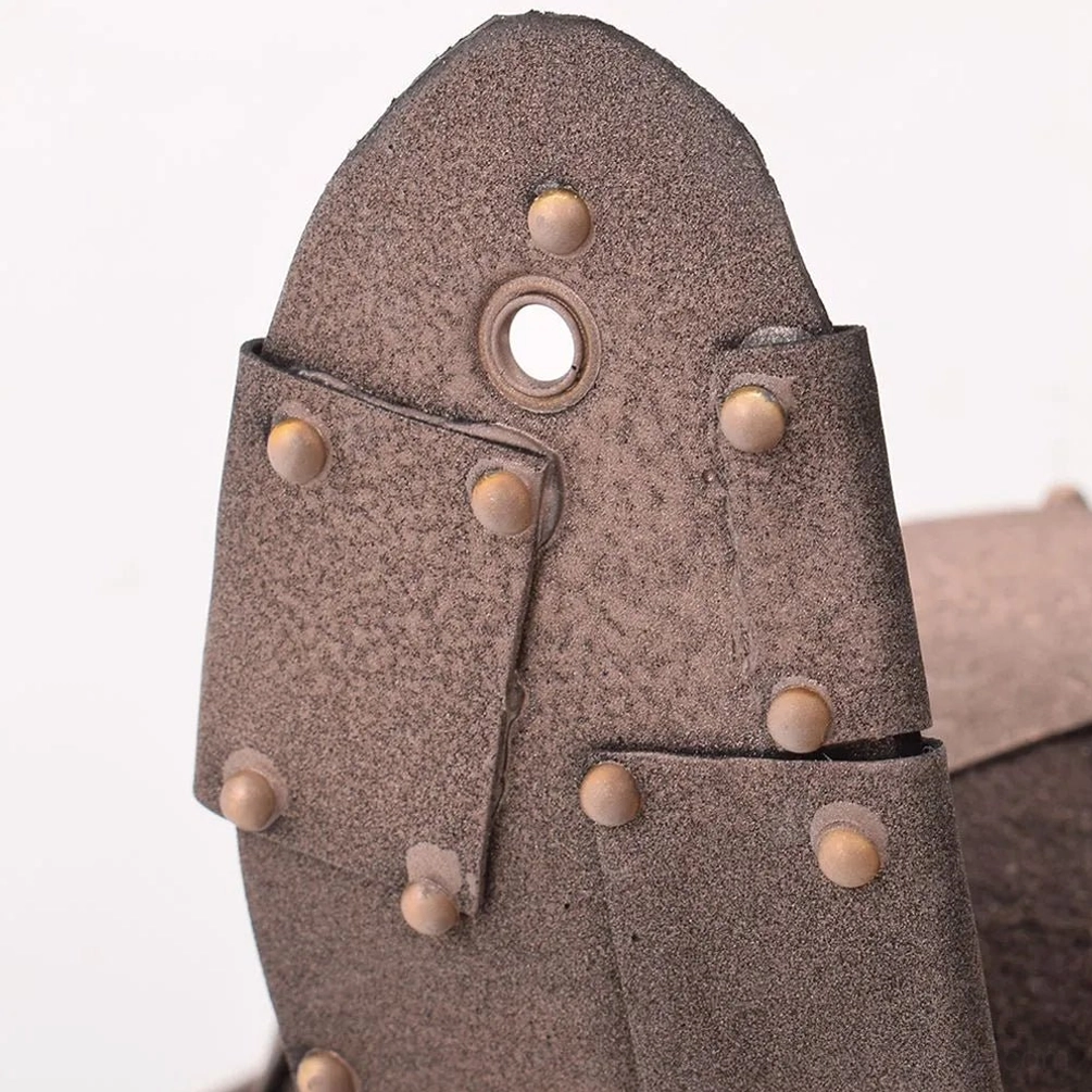 Close-up detail of steampunk bunny ear accessory showing faux leather texture, riveted metal plates, and attachment mounting holes