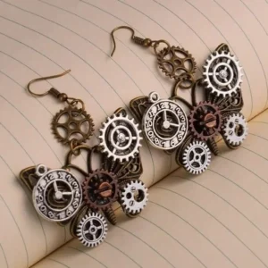 Steampunk butterfly gear earrings overhead flat lay view on ruled notebook paper, showcasing mixed metal tones and intricate clock dial details