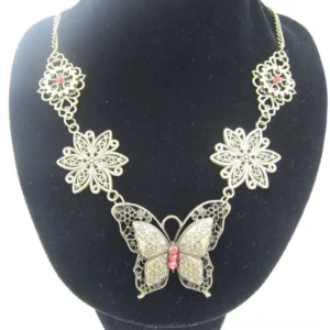 Steampunk butterfly necklace displayed on black jewelry bust, featuring vintage bronze finish with red gem accent and ornate silver filigree floral details on pendant