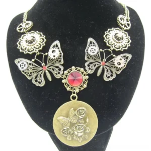 Antique steampunk butterfly necklace with mechanical rose design and red gemstone centerpiece displayed on black jewelry bust, showcasing pendant detail