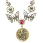 Steampunk butterfly necklace with carved rose pendant featuring gears and red crystal accent, displayed flat on white background with vintage bronze finish