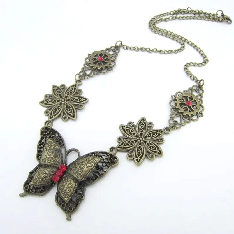 Steampunk butterfly necklace side angle view showing coiled bronze chain, hollow floral decorations, and red gemstone accents on white background