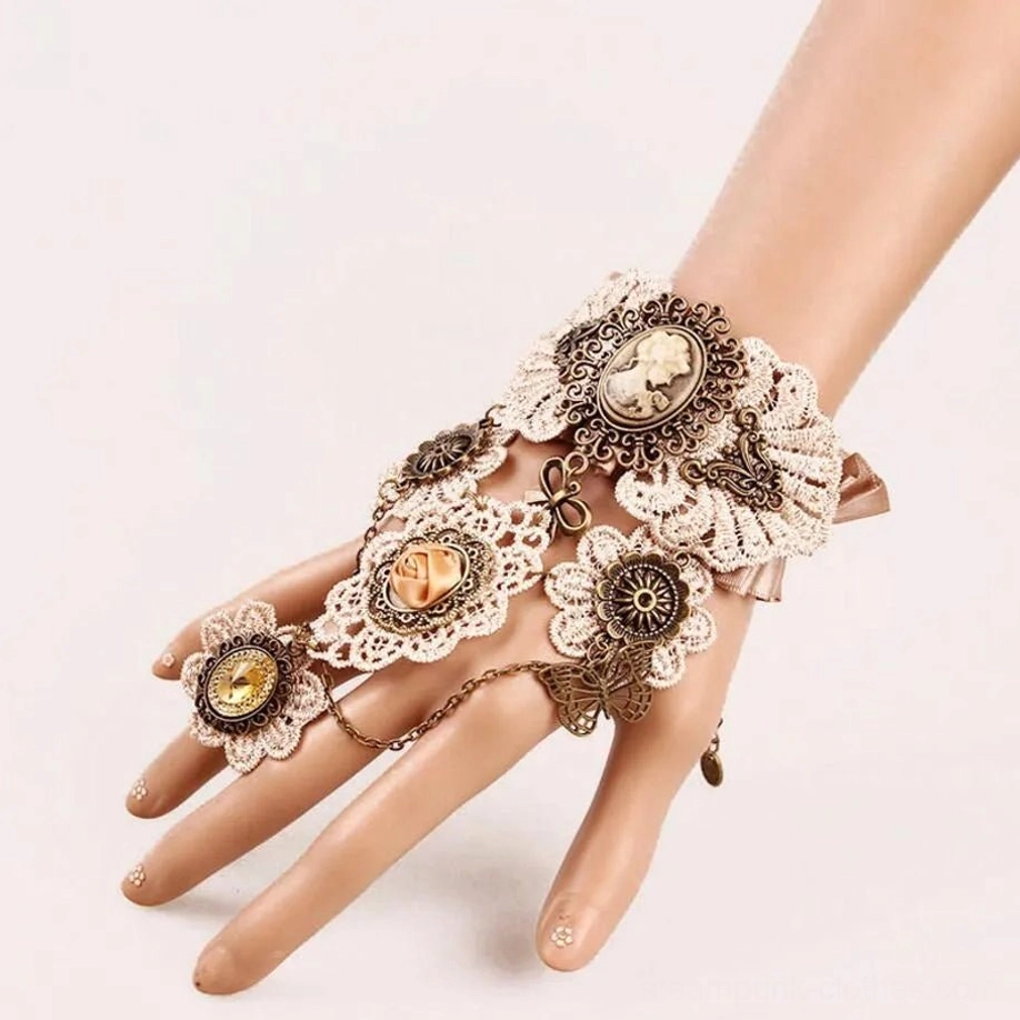 Steampunk cameo finger glove side-front view on mannequin displaying beige crochet lace, antique bronze parts, carved cameo brooch, rose flower decoration, and finger chain ring