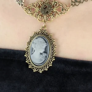 Close-up of steampunk cameo necklace filigree choker with ornate metal frame and gear ornament detail