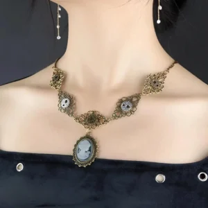 Steampunk cameo metal necklace worn on female neck showing antiqued brass filigree details and gear accents