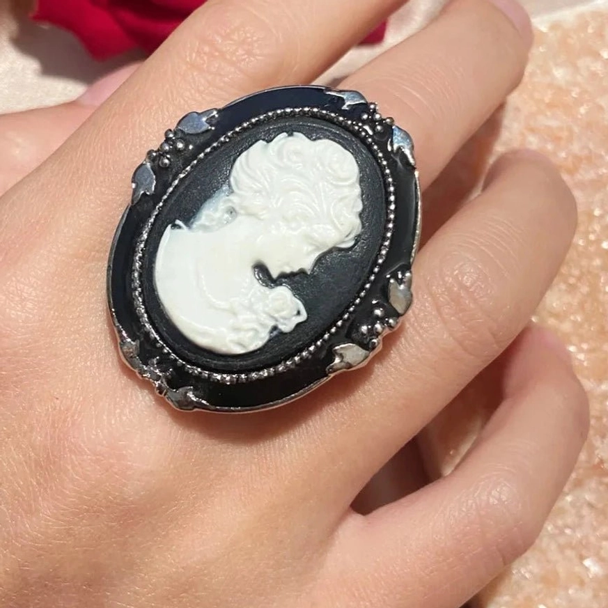 Cameo ring on hand wearing - close-up of vintage gothic black and white design steampunk aesthetic