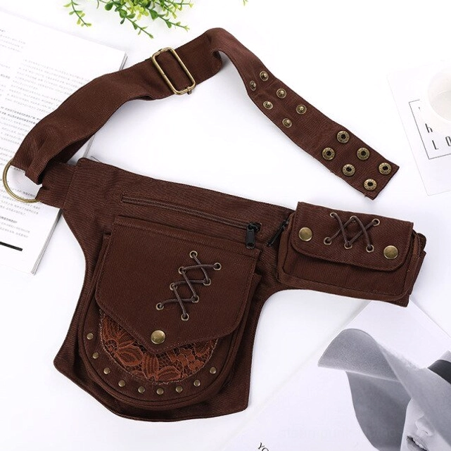 Brown steampunk canvas hip bag with hand-stitched lace-up trim and solid brass hardware, flat lay desktop background