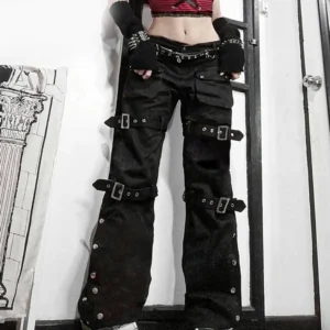 Front view of steampunk cargo pants on model indoors showing studded waist belt and silver buckle details with low-rise silhouette