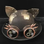 Steampunk cat ears bowler hat with bronze riveted ears and gear-spiked goggles, front three-quarter view on black background