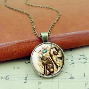 Steampunk cat necklace with antique bronze chain displayed against leather notebook and sheet music, showcasing mechanical feline design with vintage aesthetic