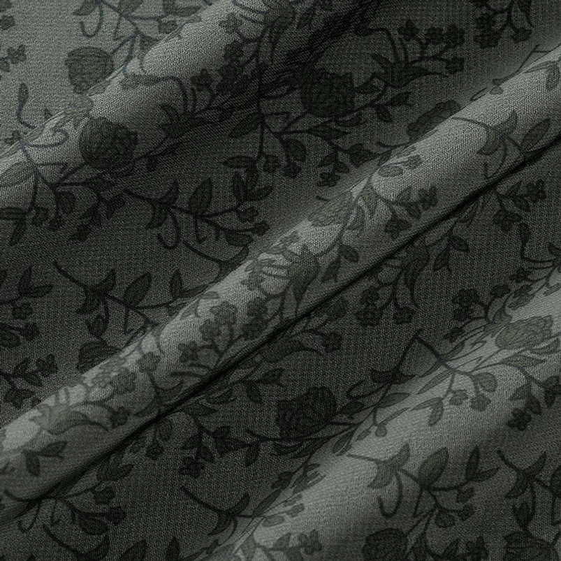Close-up detail of tonal floral vine print on sheer olive green chiffon fabric texture