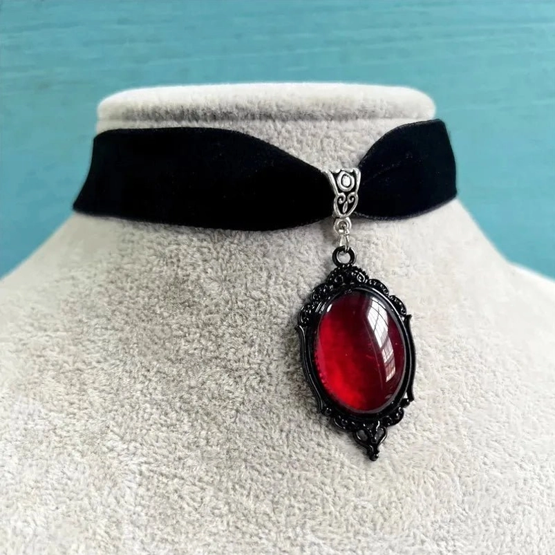 Black velvet choker necklace with red gem pendant displayed on mannequin, flat front view showing full pendant detail