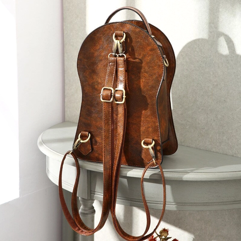 Steampunk clock bag back view showing dual adjustable backpack-style straps with brass metal adjusters and structured leather silhouette