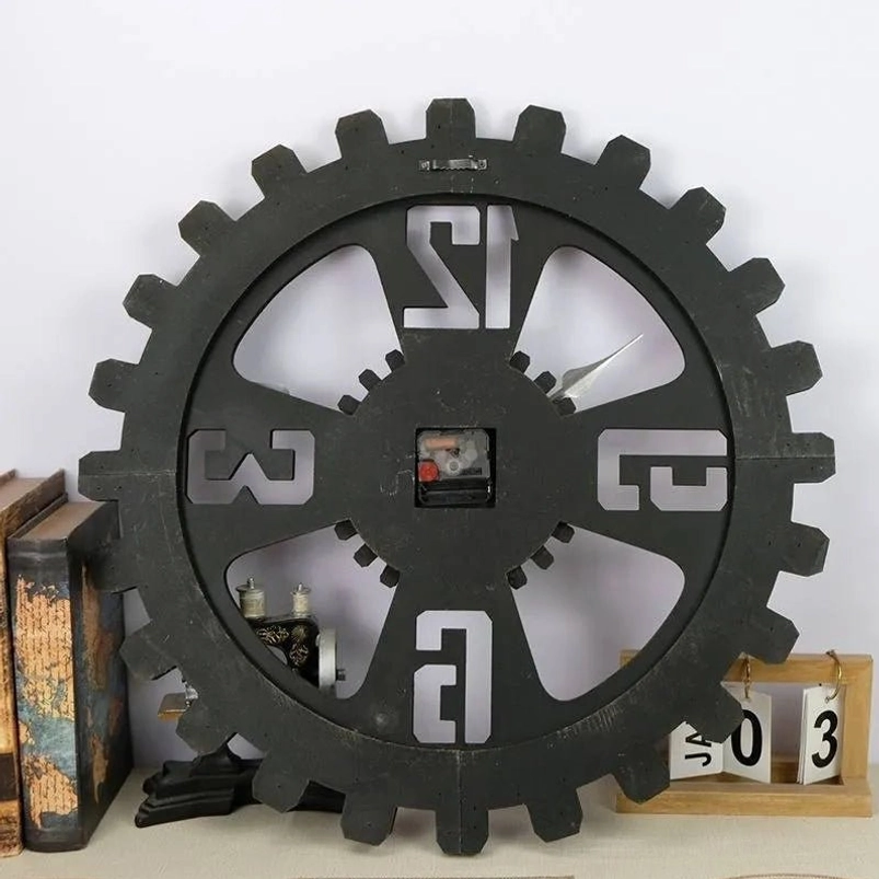 Industrial steampunk wall clock with matte black coating and exposed quartz movement displayed on tabletop with vintage home decor - eye-level perspective