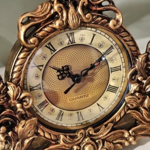 Close-up of steampunk clock face showing beige dial with black Roman numerals, ornate carved bezel, and quartz movement logo detail