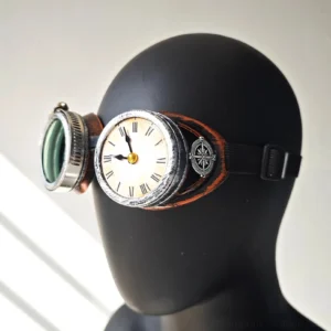 Steampunk clock goggles with aged copper trim and green tinted polycarbonate lenses, featuring Roman numeral clock decoration and compass accent, worn on black mannequin head against gray background