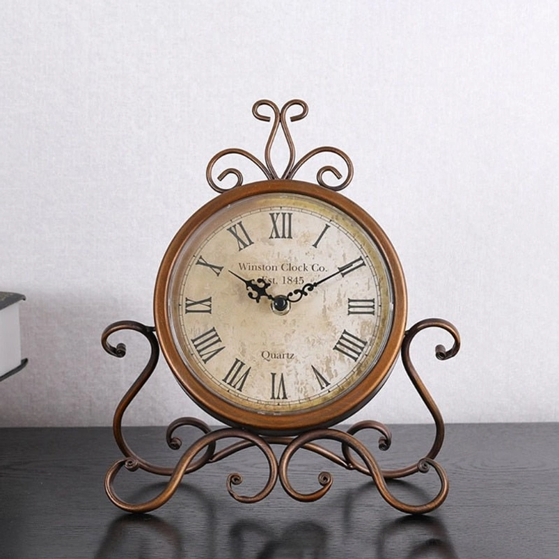Steampunk desk clock with curled wrought iron stand base and retro round clock face on wooden table