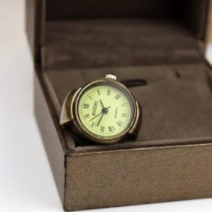 Functional steampunk watch ring with light beige dial displayed in brown gift packaging, showing top-front perspective