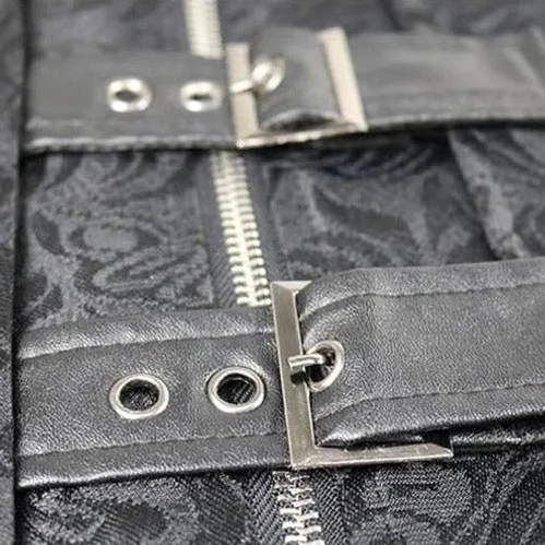 Close-up detail of steampunk coat front closure showing metal zipper, leather buckle straps, metal eyelets, and dark jacquard fabric texture