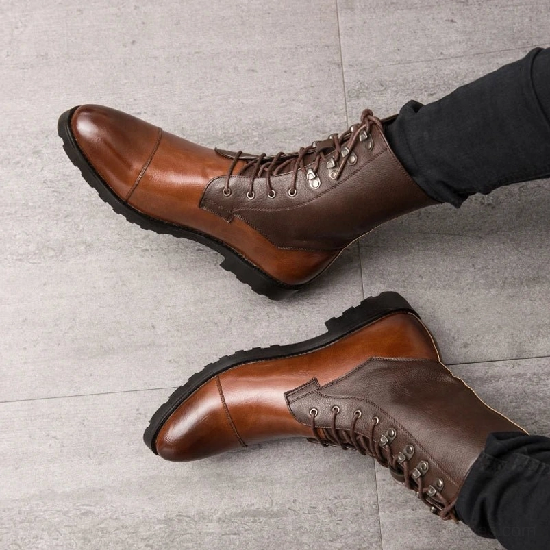 Top-down overhead flat lay of men's steampunk lace-up combat boots featuring gradient brown split leather, reinforced cap toe design, thick non-slip rubber sole with mechanical texture, and decorative metal lace eyelets