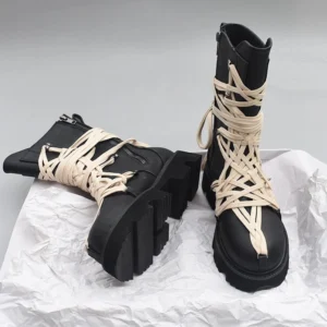 Black steampunk combat ankle boots side view with thick lug sole and off-white cross-tied laces