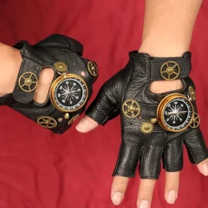 Black leather steampunk compass fingerless gloves with brass gears and chain-hung compass detail on model forearm, front three-quarter view against red background