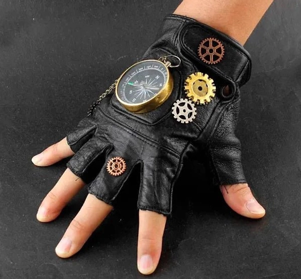 Single steampunk fingerless glove side profile showcasing chain-suspended compass with scale markings and multi-toned brass gears on black leather, close-up on grey background
