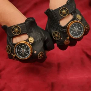 Steampunk compass fingerless gloves rear view showing mixed metal gear accents and mounted pocket compass on leather cuff, three-quarter back angle with red fabric backdrop