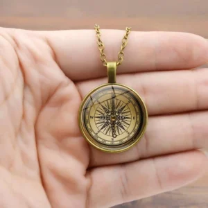 bronze steampunk compass pendant necklace held in palm, showing brass gold tone link chain and detailed compass face