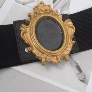 Close-up flat lay of steampunk baroque belt featuring ornate gold-plated carved frame buckle, black elastic band, and metal snap fasteners on vintage magazine background