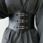 Black steampunk corset belt with three golden metal buckles worn over gray formal suit, front view showcasing split-front leather design, elastic band construction, and cinched waist silhouette
