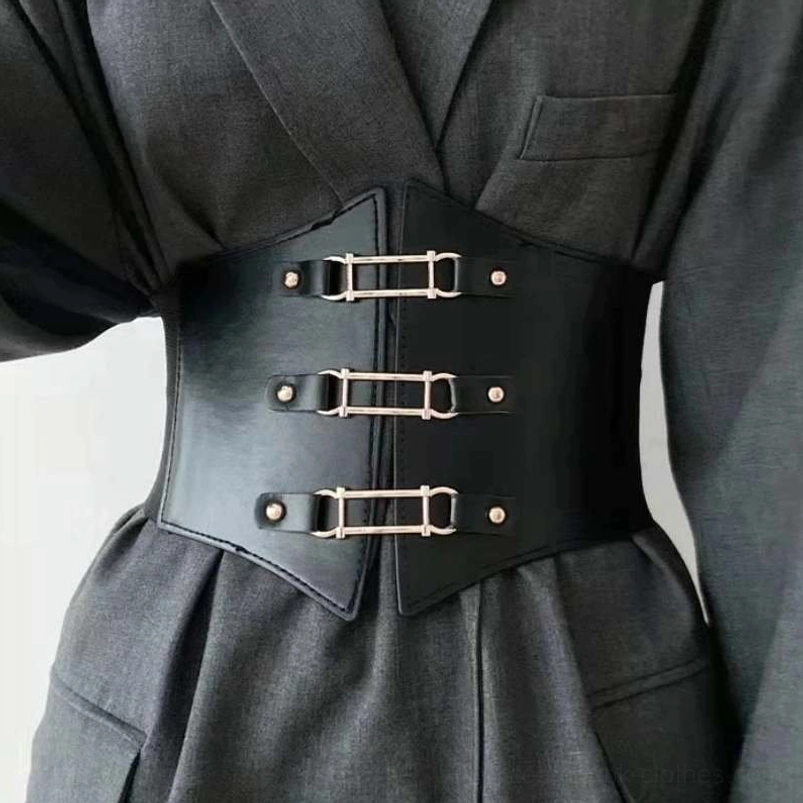 Black steampunk corset belt with three golden metal buckles worn over gray formal suit, front view showcasing split-front leather design, elastic band construction, and cinched waist silhouette