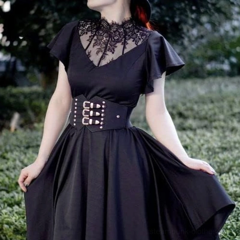 Steampunk corset waist belt with triple silver engraved buckles and stud details styled on model wearing black vintage gothic dress in garden