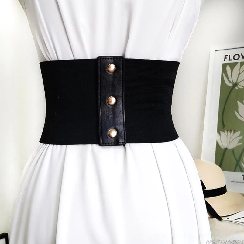 Close-up front view of steampunk waist belt featuring elastic side panel construction, metal snap button closure mechanism, and laced corset-style front detail on dress form wearing white dress for styling reference