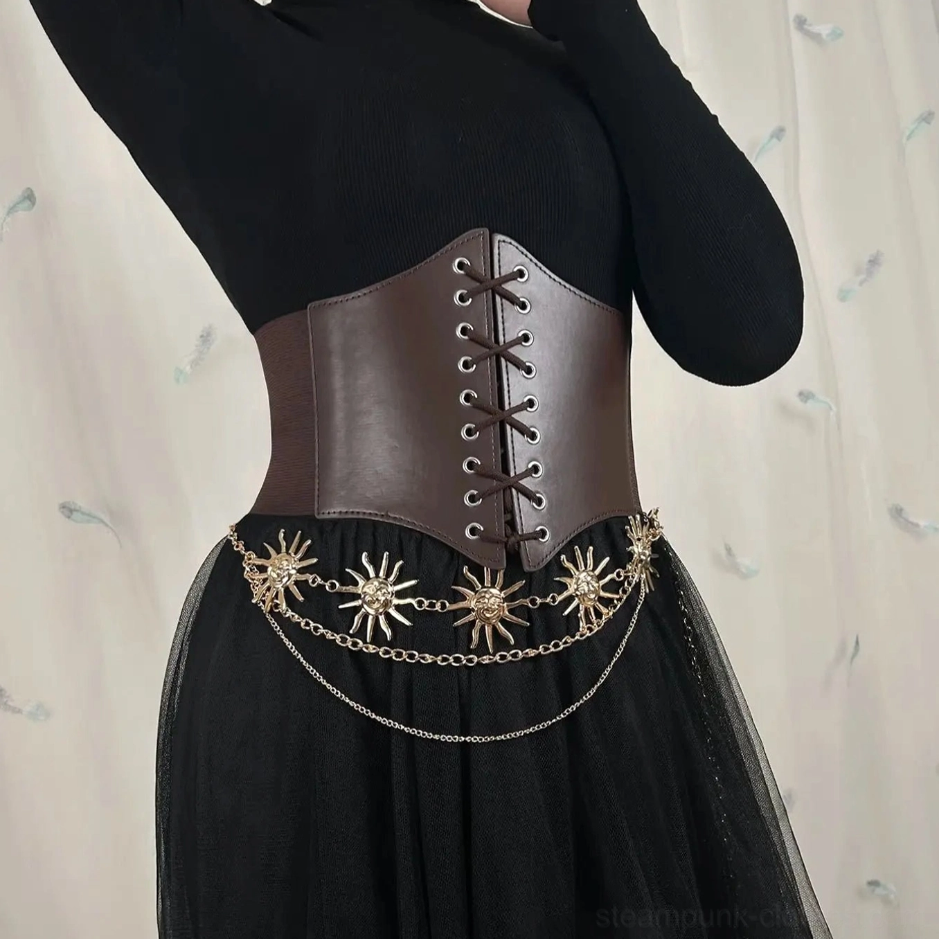 Brown leather steampunk underbust corset belt with intricate sun-shaped metal chain decoration styled with black skirt, side front angle showcasing lace-up closure and cinching mechanism