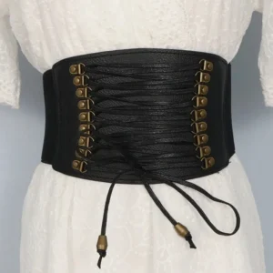 Wide black steampunk corset belt with antique bronze hardware and traditional lace-up closure system, displayed on mannequin wearing white lace dress, front studio view showing full silhouette enhancement