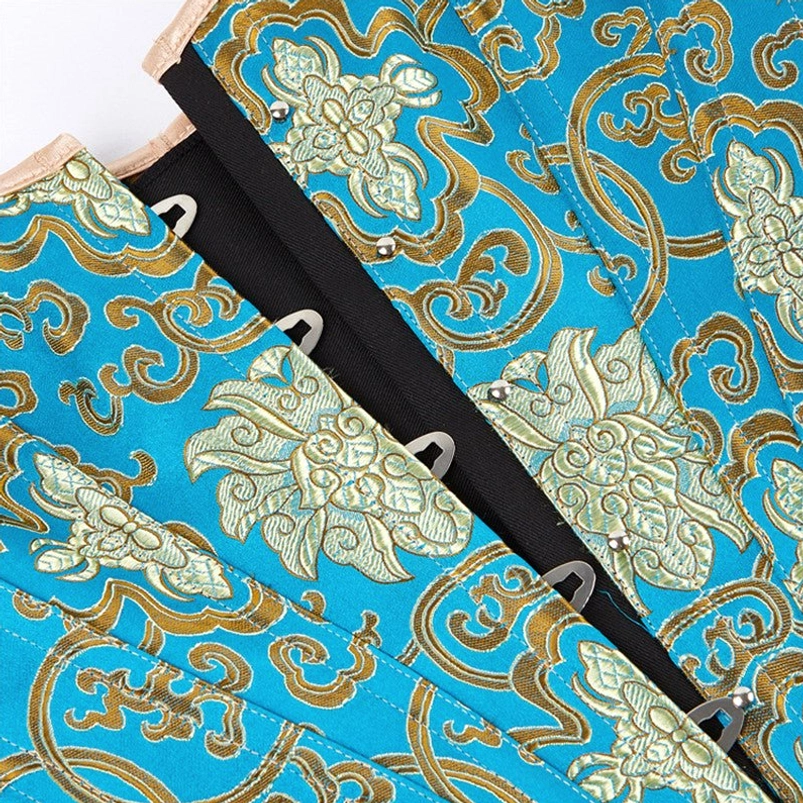 Close-up fabric detail of blue and gold floral brocade steampunk corset showing front hook-and-eye closure, lace-up slots, and metal stud reinforcement