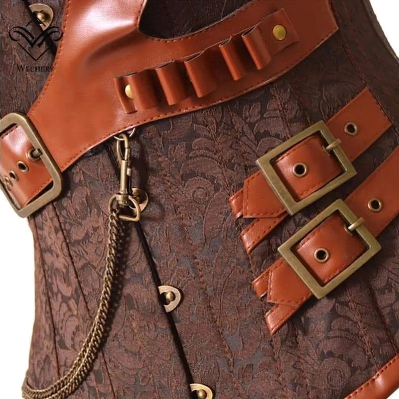 Close-up detail of steampunk corset construction showing brown jacquard base, leather ammo strap, dual metal buckles and decorative metal chain
