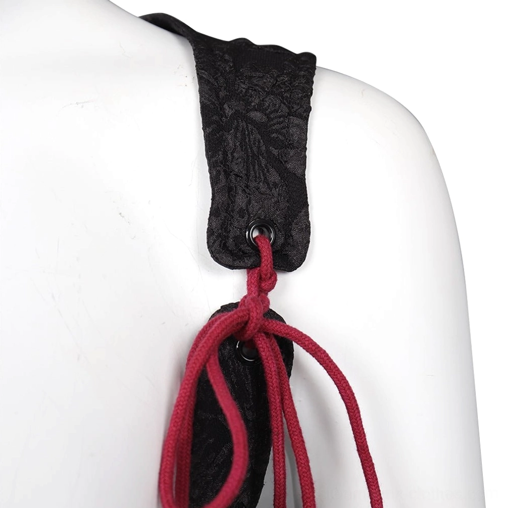 Side detail view of steampunk corset shoulder strap showing black jacquard construction, red lace tie cord, metal eyelet adjustment hardware, and structural engineering