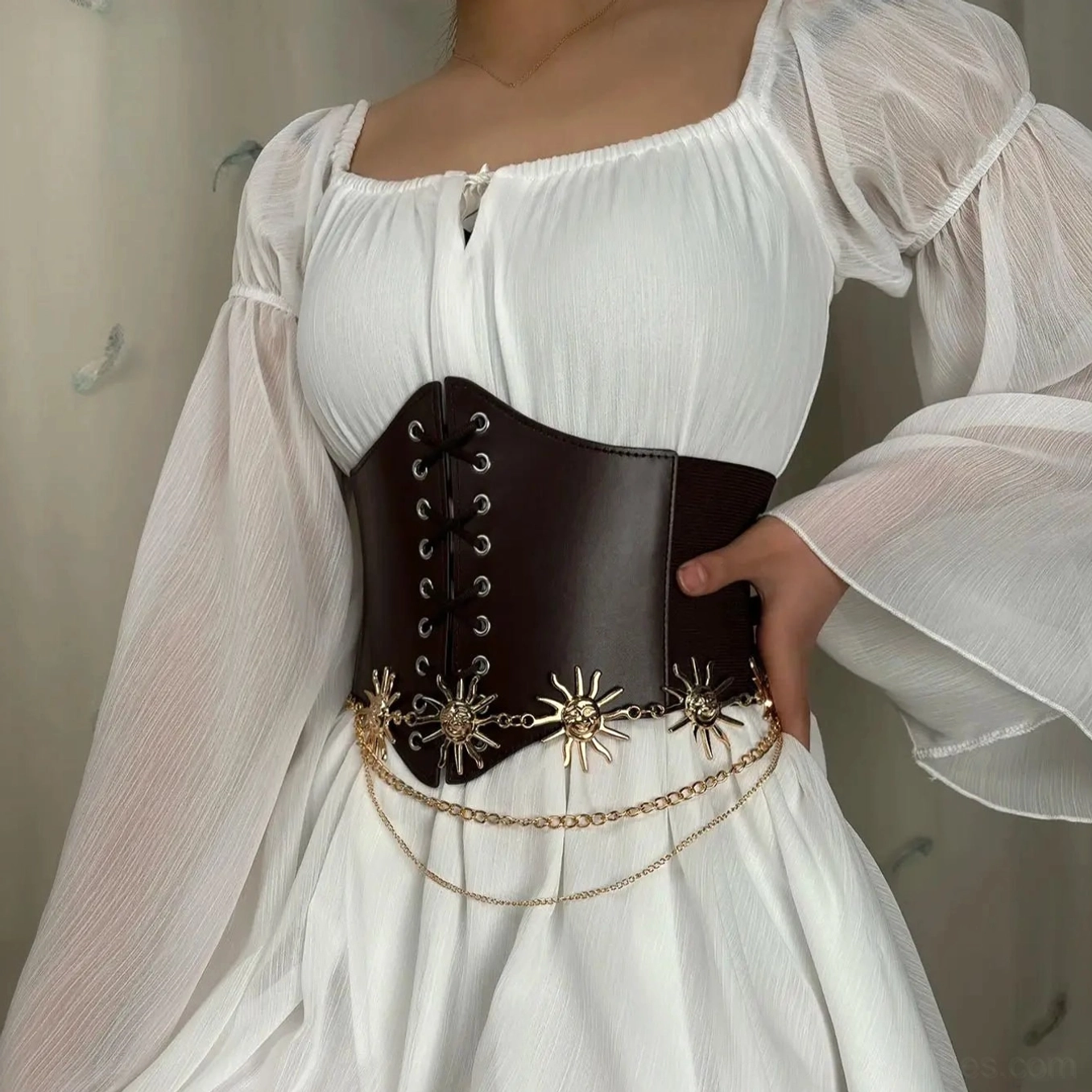 Victorian steampunk underbust corset belt with ornamental layered gold sun chains styled over flowing white long-sleeve renaissance dress, three-quarter angle view demonstrating cinching silhouette