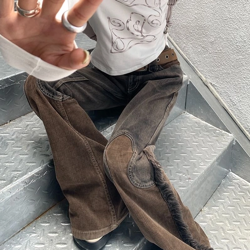 Close-up detail of steampunk cowgirl flare pants showing reinforced knee patches, mixed fabric texture, frayed side seams, and authentic distressed finishing