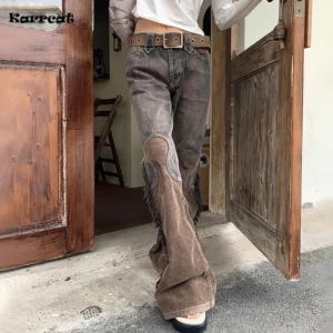 Steampunk cowgirl flare pants with two-tone brown denim and corduroy panels, frayed side seams, and reinforced knee patches, worn with wide leather belt and outdoor wooden doorway backdrop